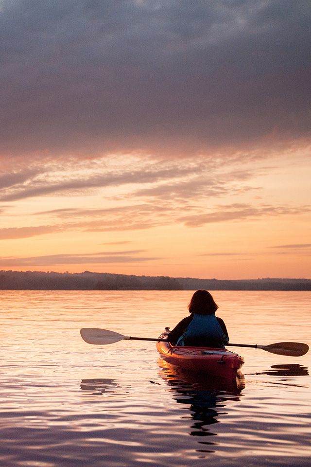 Kayaker on the ocean looking at the sunset near Courtenay, BC